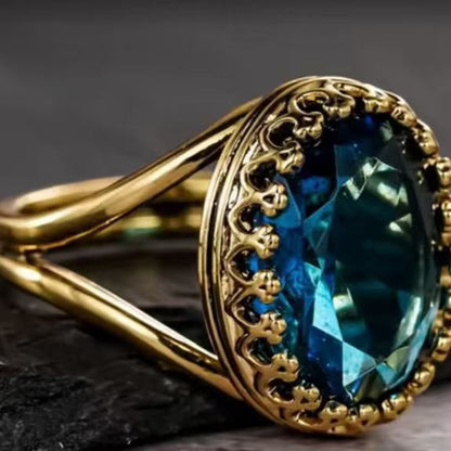 Gold ring with a blue gemstone on a dark background