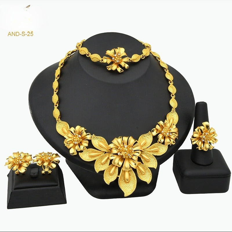 Gold floral jewelry set on a black stand with 'AND-S-25' text.