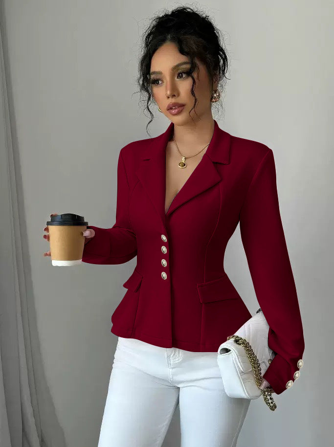 Woman in a red blazer holding a coffee cup against a neutral background