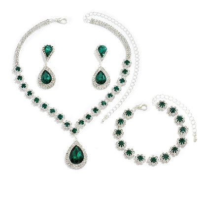 Green gemstone jewelry set including necklace, bracelet, and earrings on a white background