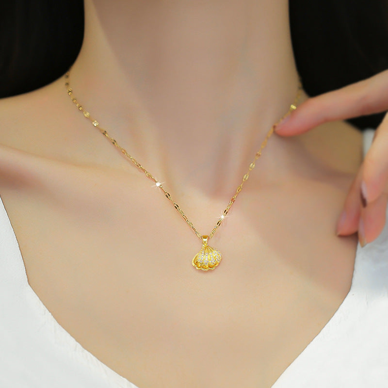 Gold necklace with a small pendant on a person's neck