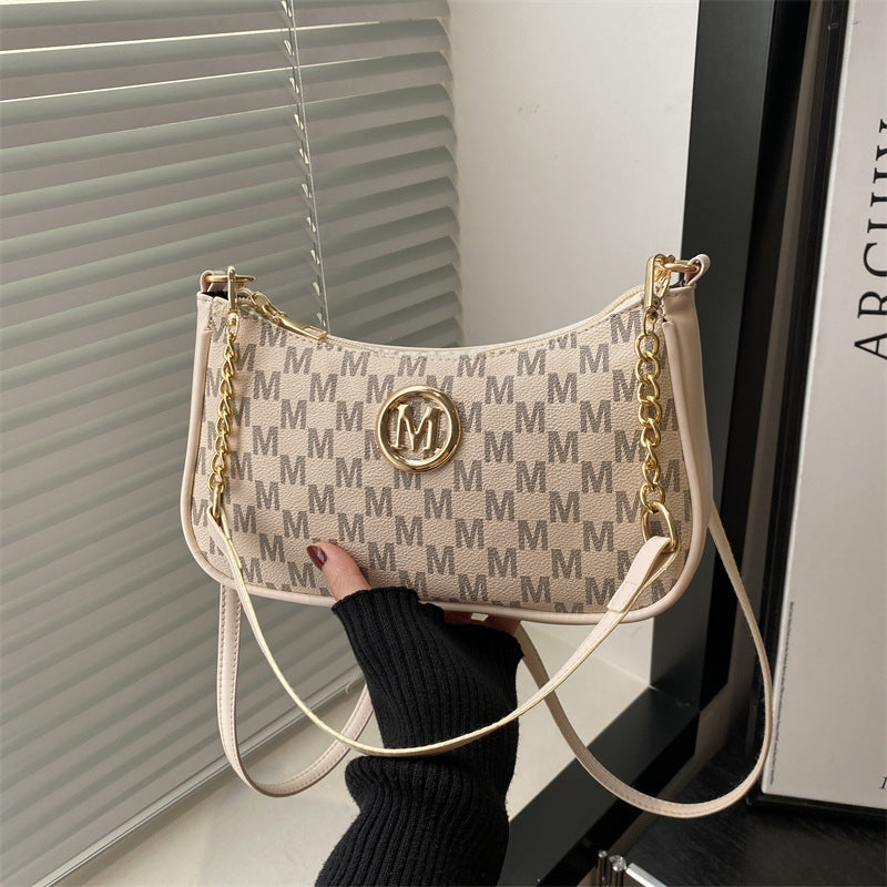 Women’s light tan monogram shoulder pouch bag with long white strap and gold hardware