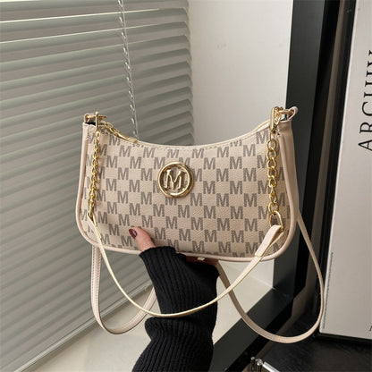 Women’s light tan monogram shoulder pouch bag with long white strap and gold hardware