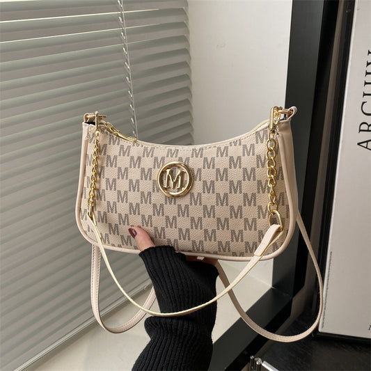 Women’s light tan monogram shoulder pouch bag with long white strap and gold hardware
