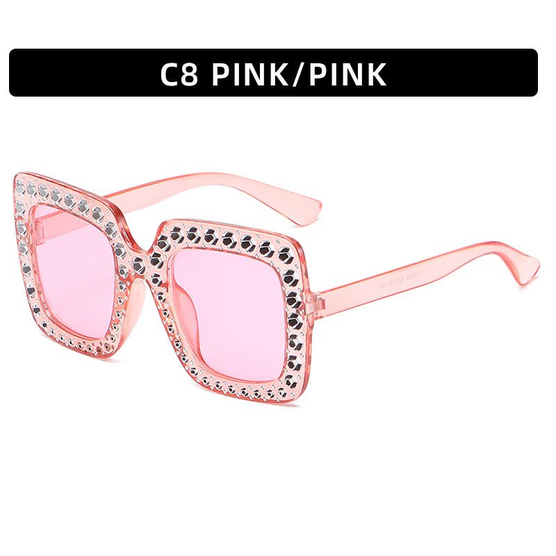Pink sunglasses with rhinestone details on a white background