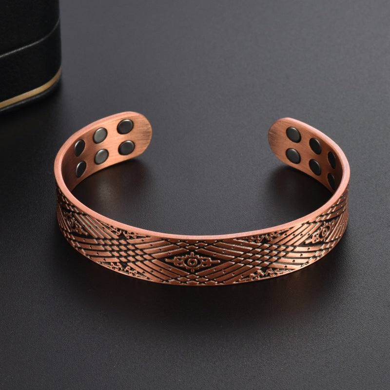 Copper bracelet with intricate design on a dark background