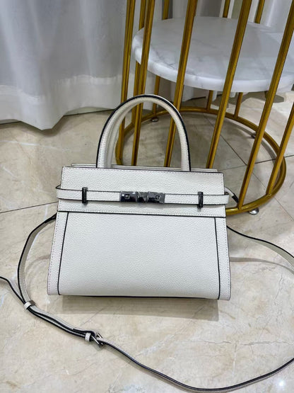 White handbag with a black strap on a marble floor