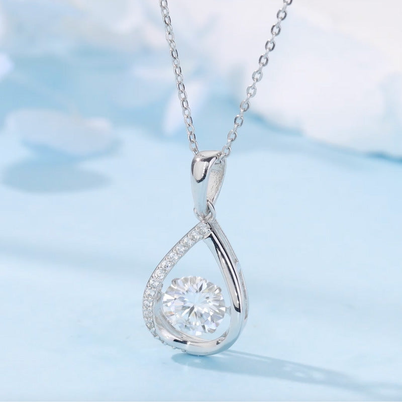 Silver teardrop-shaped pendant with a diamond on a light blue background