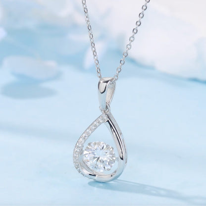 Silver teardrop-shaped pendant with a diamond on a light blue background