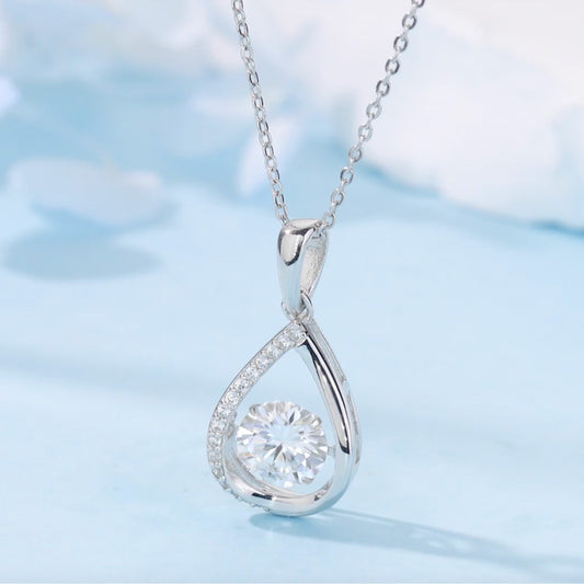 Silver teardrop-shaped pendant with a diamond on a light blue background