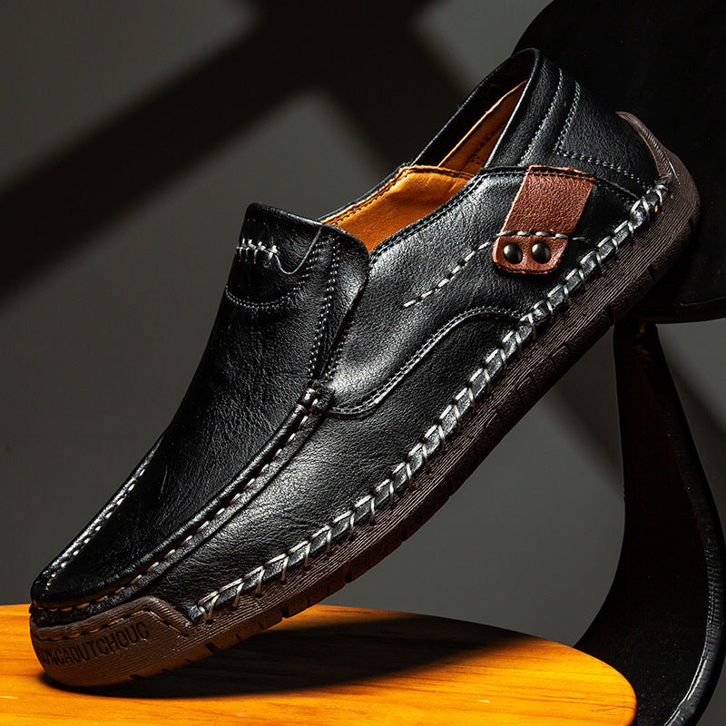 Black leather loafer shoe on a wooden surface with a dark background