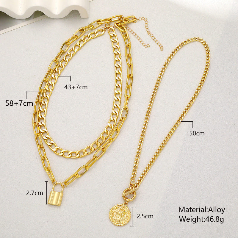 Layered gold-tone chain necklace set with circular pendant and two padlock pendants