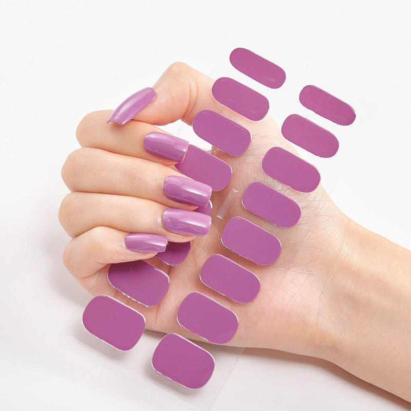 Hand with purple nail polish and additional nail pads on a white background