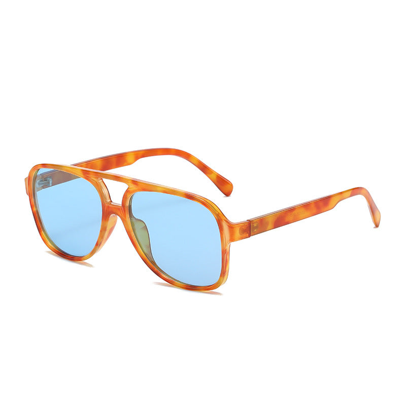Sunglasses with tortoiseshell frame and blue lenses on a white background