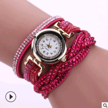 Multilayered bracelet with a watch face on a wrist against a white background