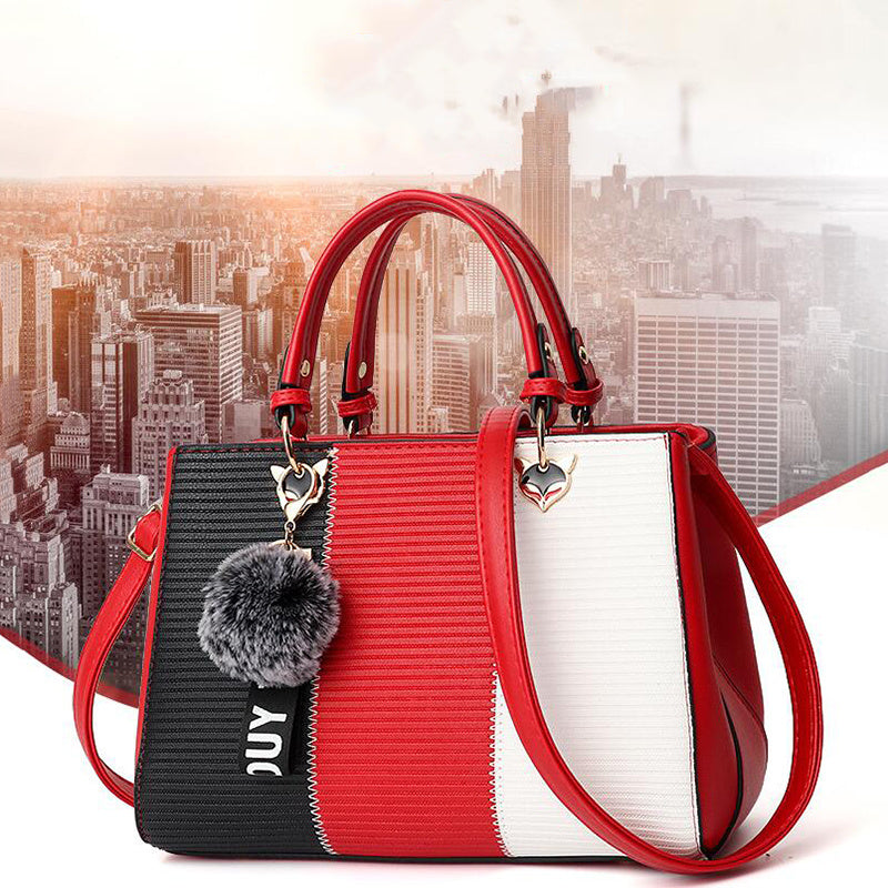 Multicolored handbag with red handles and a cityscape background