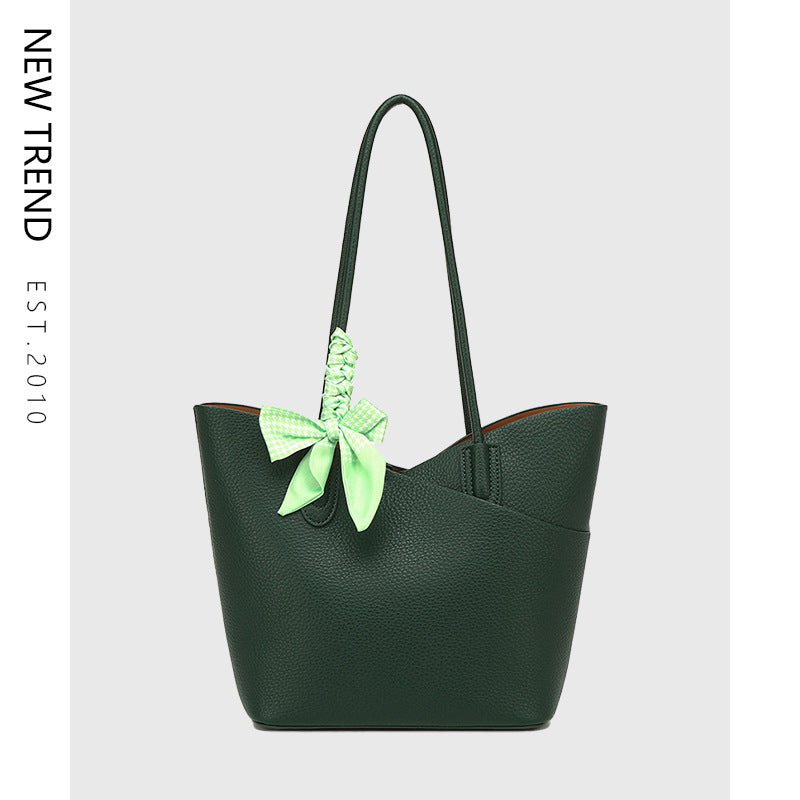 Green handbag with a green bow on a light gray background