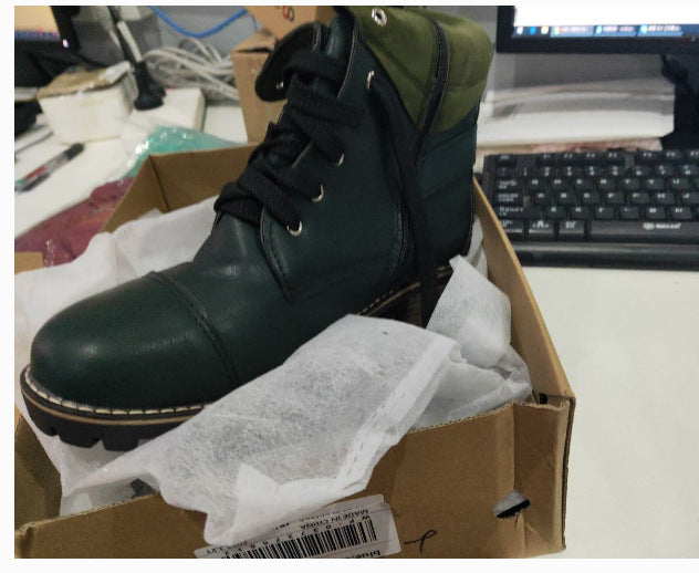 Green leather boot in a cardboard box with a computer keyboard in the background