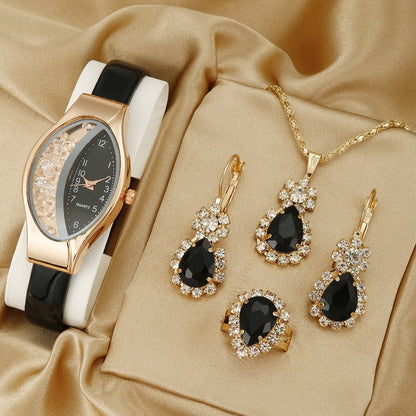 Jewelry set with a watch and black gemstone earrings on a beige fabric background