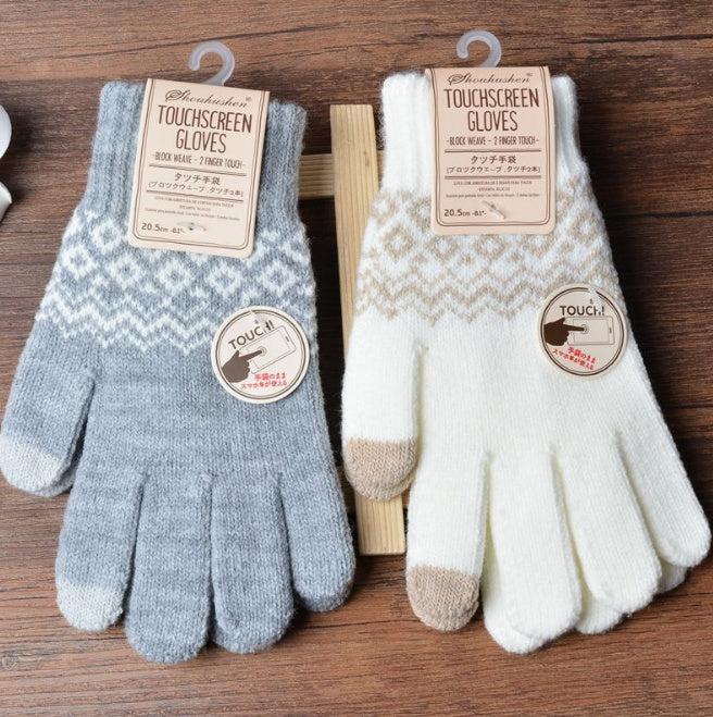 Pair of touchscreen gloves with gray and white patterns on a wooden surface