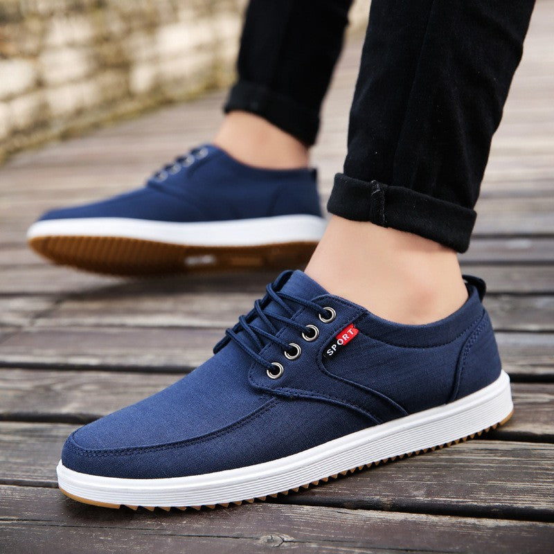 Navy blue casual shoes with white soles on a wooden floor