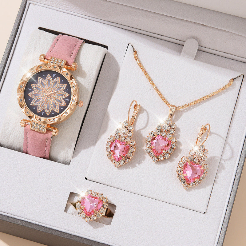 Jewelry set with pink gemstones including a watch, necklace, and earrings on a white box.