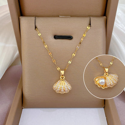 Gold necklace with shell pendant and pearl detail in a box