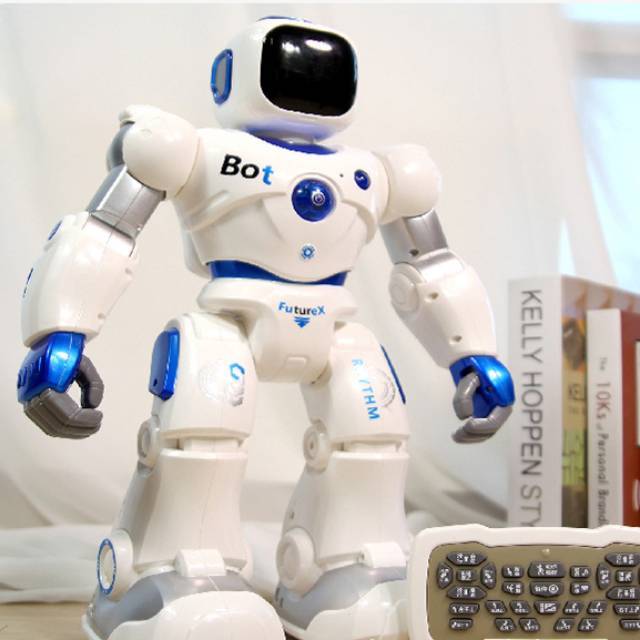 White robot toy with blue accents on a surface with books in the background