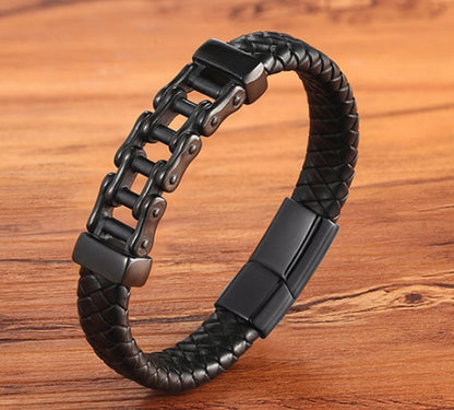 Black braided leather bracelet with metal links on a wooden surface