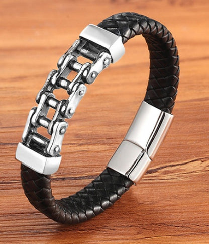 Black braided leather bracelet with silver chain and clasp on a wooden surface