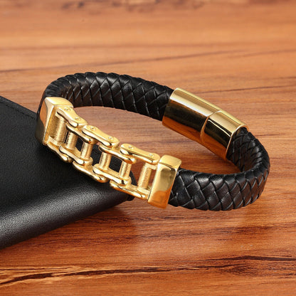 Black braided leather bracelet with gold clasp on a wooden surface