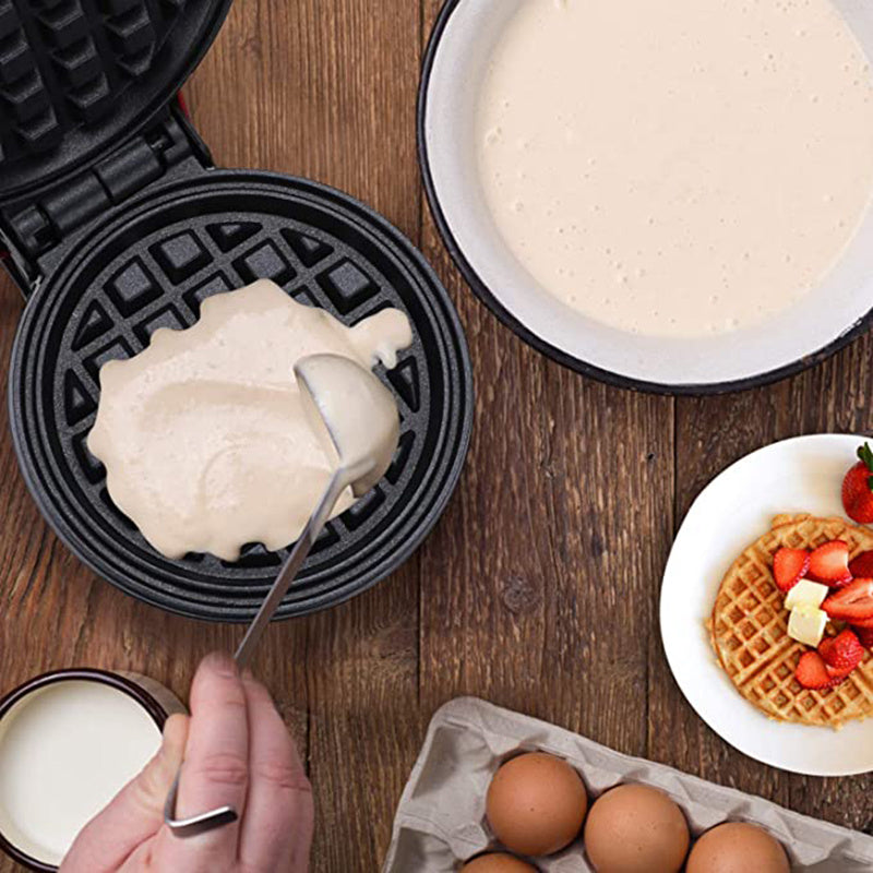 Making waffles with a waffle maker on a wooden table.