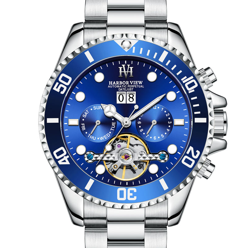 Men's tourbillon automatic watch with blue dial, gold bezel accents, and silver bracelet
