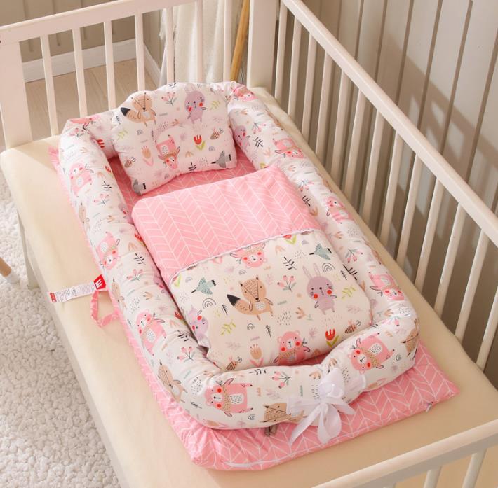 Baby crib with pink and white crib bumper and bedding