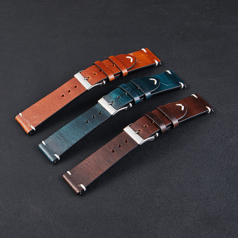 Thin leather watch straps with silver buckles in orange, teal, and brown