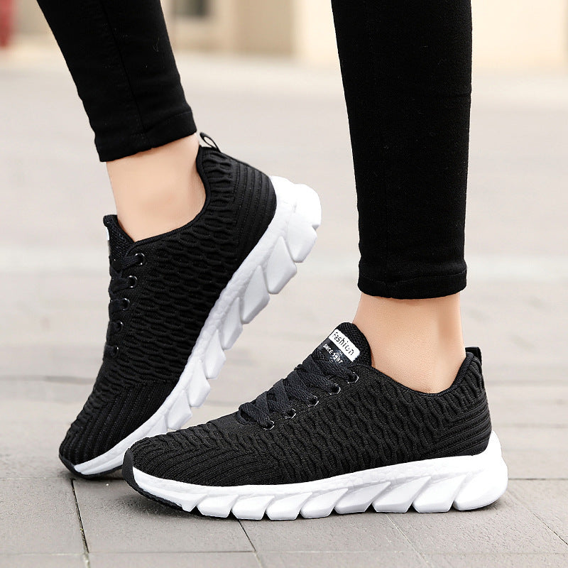 Black and white sneakers worn on a blurred background