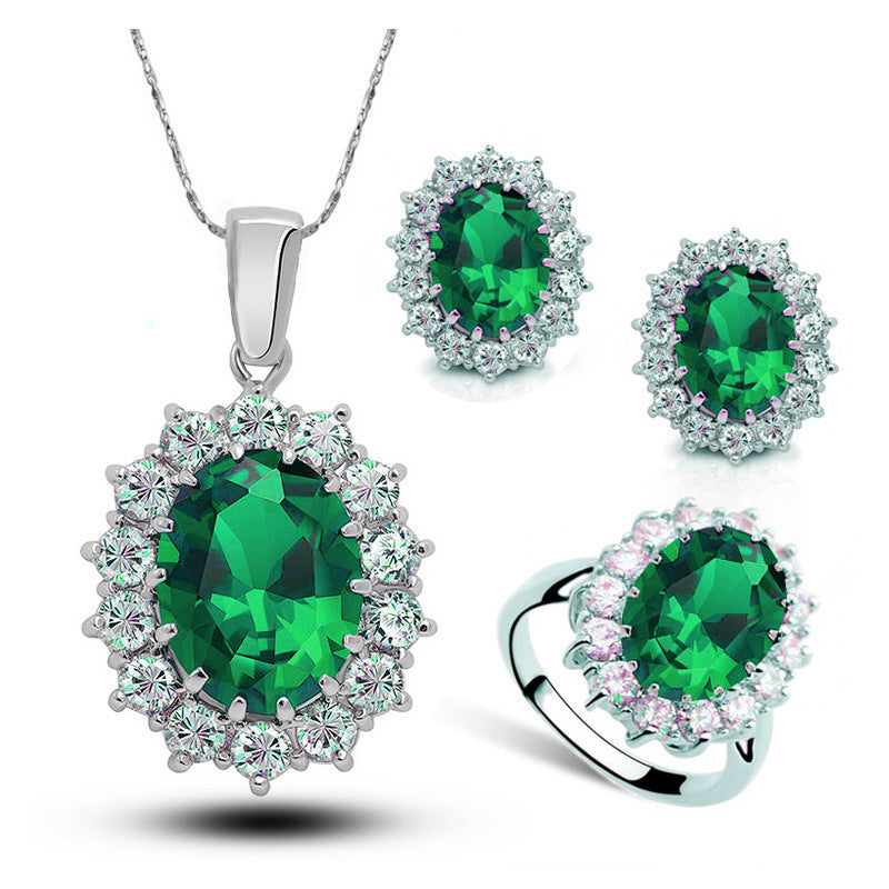 Jewelry set with green gemstones on a white background