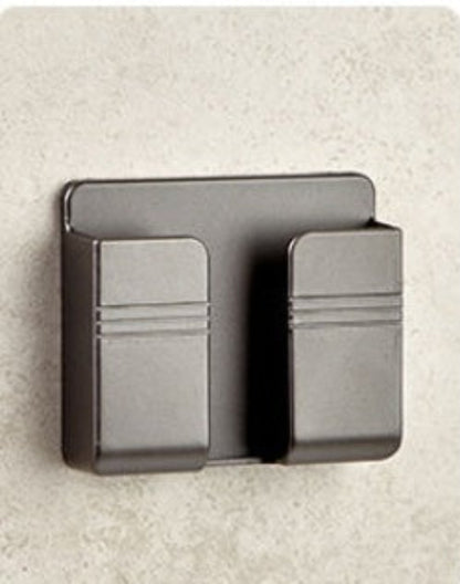 Black metal wall-mounted card holder on a beige wall