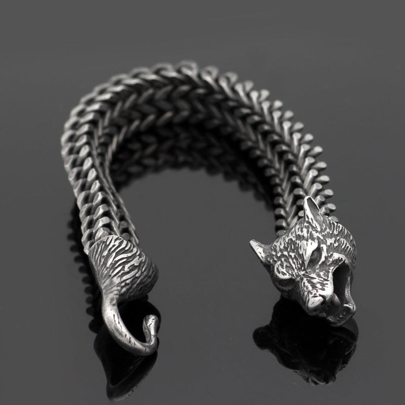 Silver cat-shaped bracelet on a reflective surface with a dark background