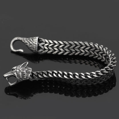 Silver braided belt with wolf head design on a black background