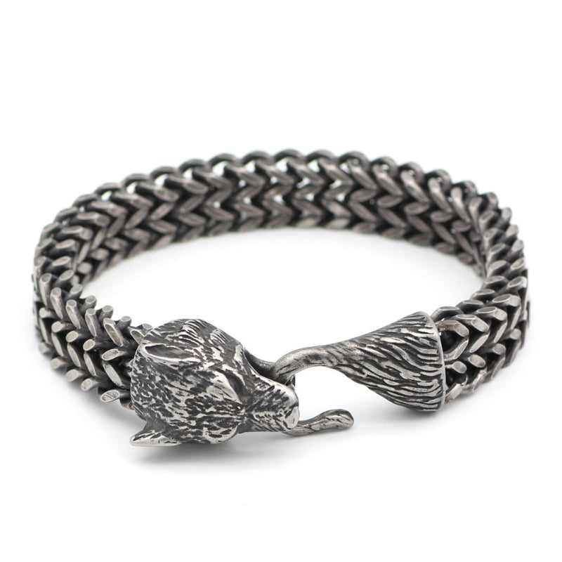 Silver chain bracelet with wolf head clasp on a white background