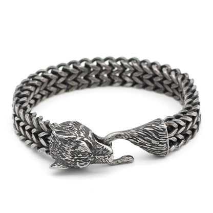 Silver chain bracelet with wolf head clasp on a white background