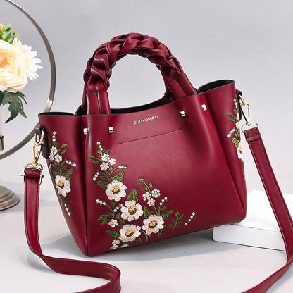 Red handbag with floral embroidery on a light background