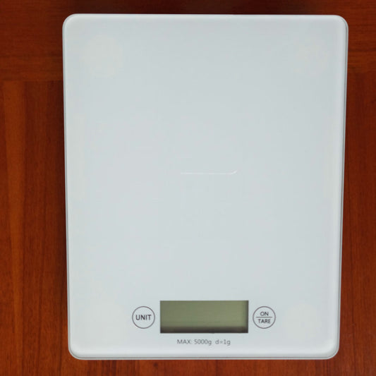 White digital kitchen scale on a wooden surface