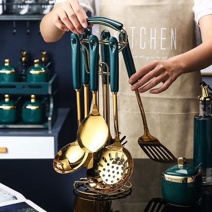 Set of gold and teal kitchen utensils held by a person in a kitchen setting.