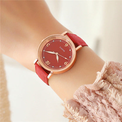 Women's quartz watch with red dial, gold-tone case, and red leather strap