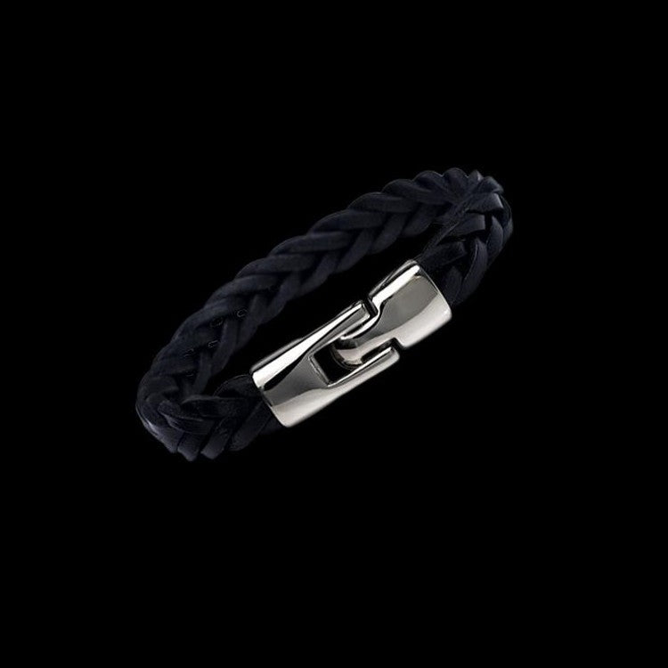 Black braided bracelet with a silver clasp on a black background