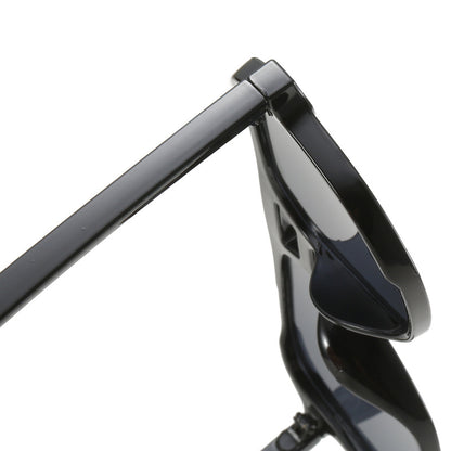 Close-up of a black motorcycle handlebar with mirror on a white background