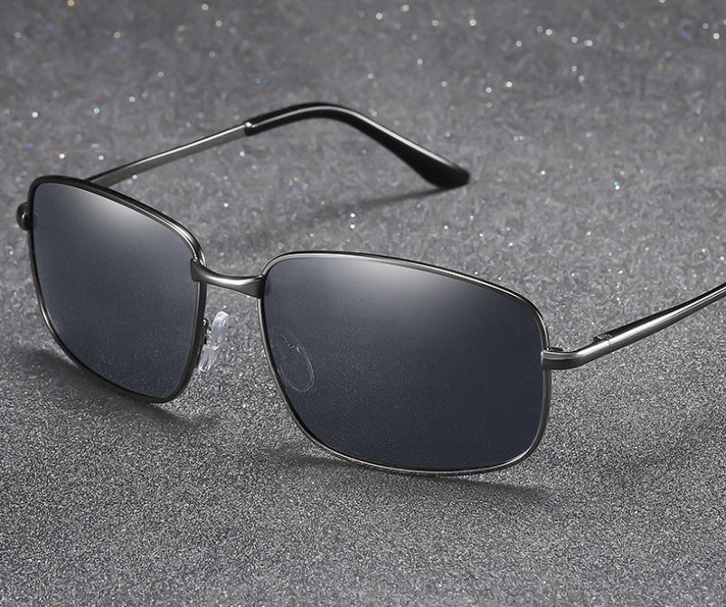 Sunglasses with dark lenses and thin metal frame on a gray textured background