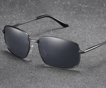 Sunglasses with dark lenses and thin metal frame on a gray textured background